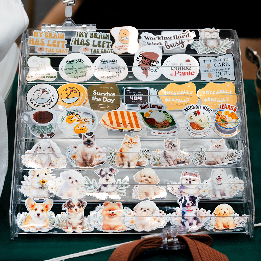 Collection of various stickers on a clear organizer with different designs including animals, text, and food.
