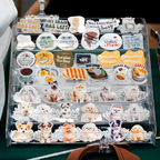 Collection of various stickers on a clear organizer with different designs including animals, text, and food.