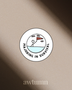 Circular sticker with a stick figure and text 'Majoring in Survival' on a beige background, with 'awtumn' branding.