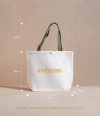 White tote bag with 'awtumn' text and measurements on a beige background